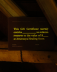 Dark gift certificate on wooden surface with yellow text